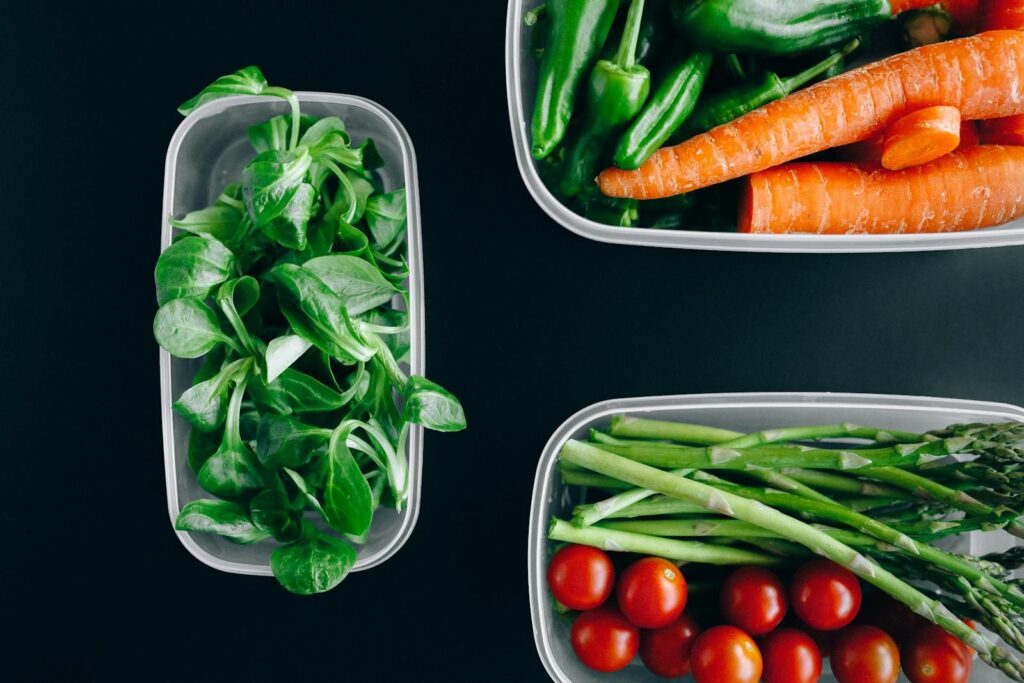Organic vegetables displayed in plastic containers for a healthy diet.