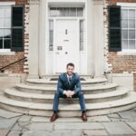 man in blue suit sitting on brown concrete stairs